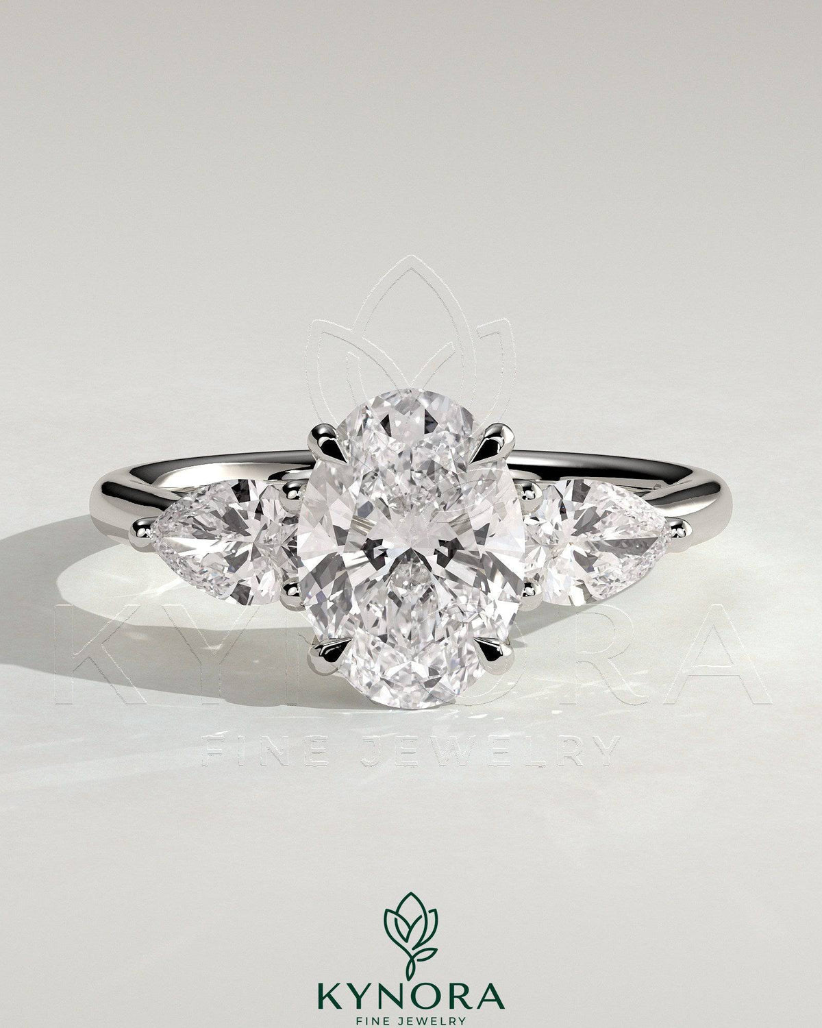 Kynora CJ 2ct oval claw trilogy engagement ring with pear side stones and open trellis gallery design, showcasing intricate craftsmanship.