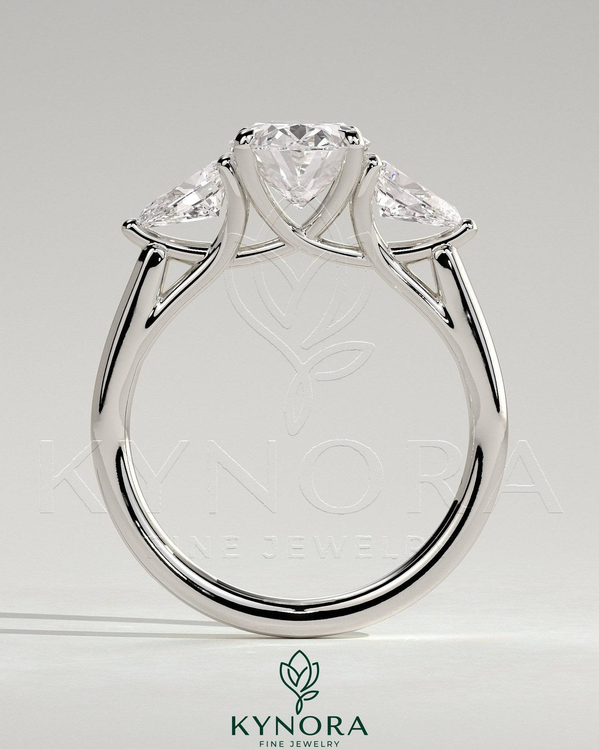 Kynora CJ 2ct oval claw trilogy engagement ring with pear side stones and open trellis gallery design.