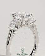 Kynora CJ 2ct oval claw trilogy engagement ring with pear side stones and open trellis gallery design.