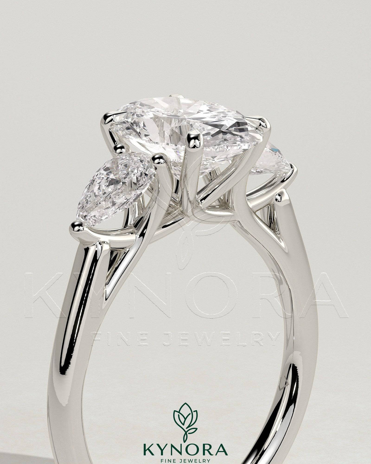 Kynora CJ 2ct oval claw trilogy engagement ring with pear side stones and open trellis gallery design.
