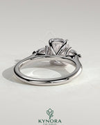 Kynora CJ three-stone engagement ring with 2-carat elongated cushion center, pear side stones, and cathedral setting.