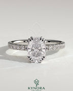 Kynora CJ 2ct elongated cushion triple claw solitaire engagement ring with pave band, featuring a central gemstone and elegant design.