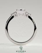 Kynora CJ 2ct emerald claw solitaire engagement ring with round shoulder stones, featuring a central emerald cut gemstone.