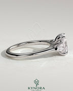 Kynora CJ 2ct elongated cushion cut trilogy engagement ring with pear side stones and cathedral setting, showcasing intricate jewel design.