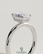 Kynora CJ 2ct emerald claw solitaire engagement ring with a wrap-around hidden halo, showcasing a sparkling emerald center stone.