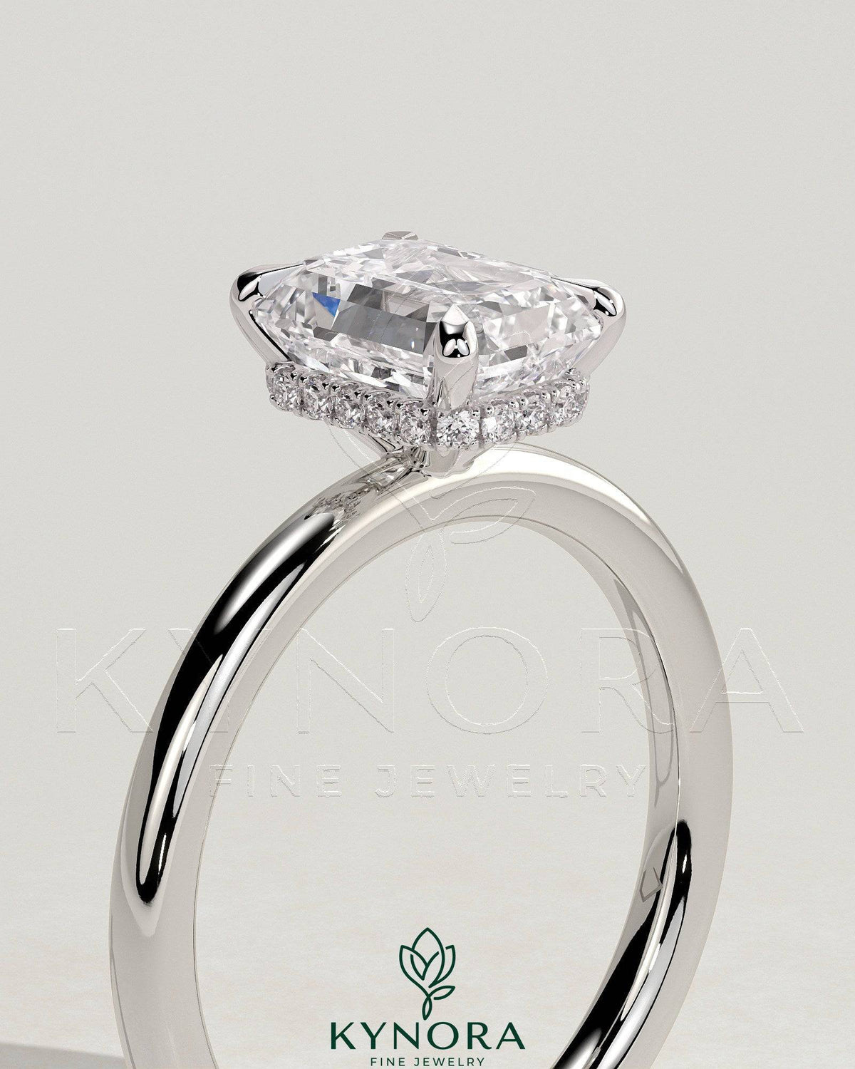 Kynora CJ 2ct emerald claw solitaire engagement ring with a wrap-around hidden halo, showcasing a sparkling emerald center stone.