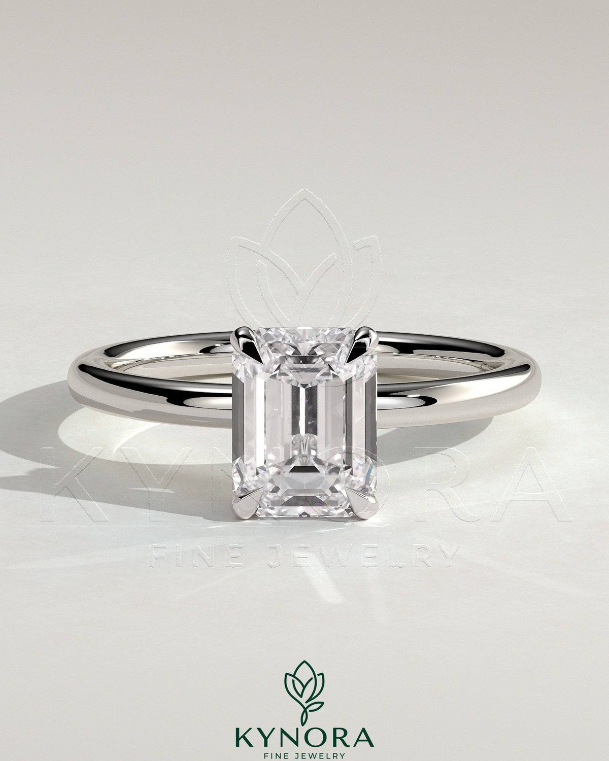 Kynora CJ 2ct emerald claw solitaire engagement ring with a wrap-around hidden halo setting, featuring a sparkling emerald center stone. Main image