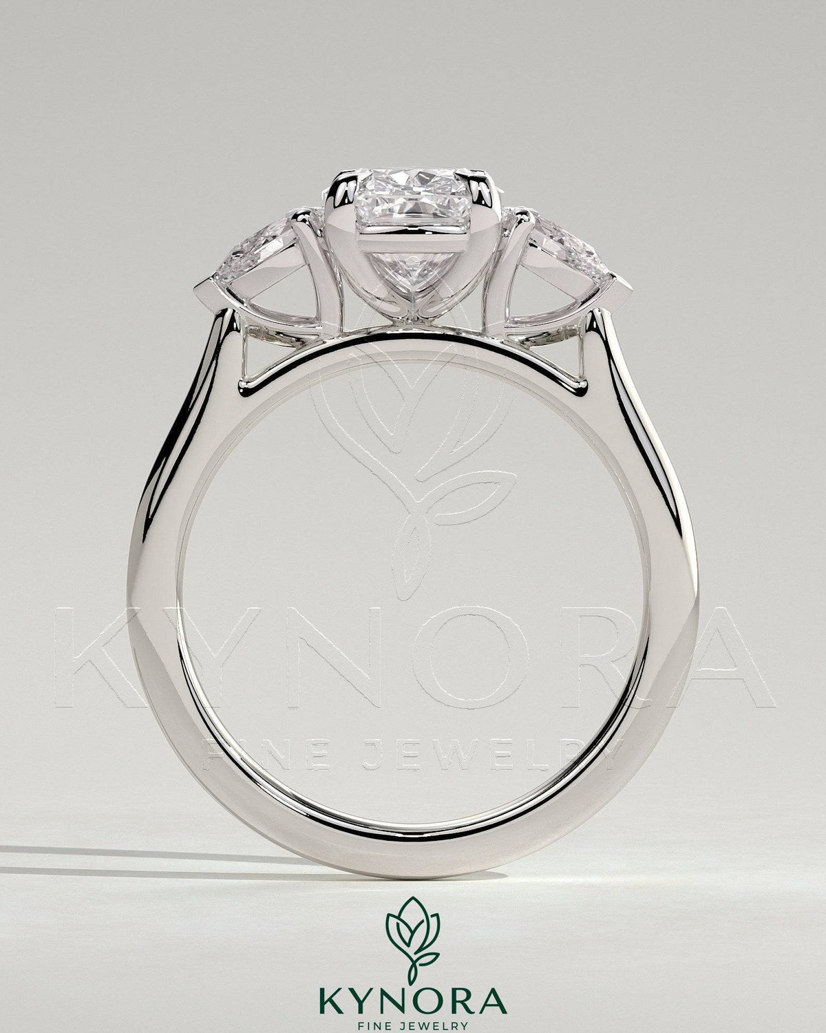 Kynora CJ 2ct elongated cushion claw trilogy engagement ring with pear side stones and cathedral setting, featuring elegant design.