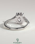 Kynora CJ 2ct oval claw solitaire engagement ring with round shoulder stones, showcasing a sparkling central gemstone and elegant design.