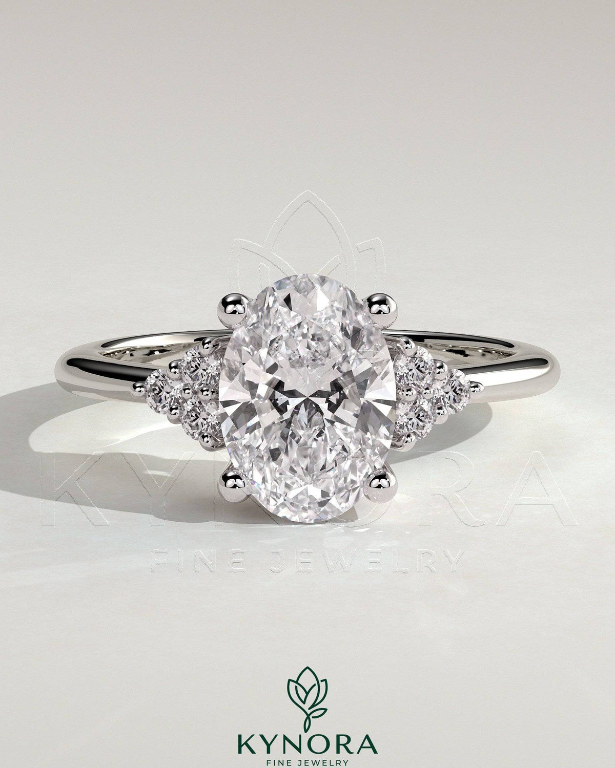 Kynora CJ 2ct oval claw solitaire engagement ring with round shoulder stones, showcasing a sparkling diamond design. Main image