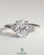 Kynora CJ 2ct oval claw solitaire engagement ring with round shoulder stones, showcasing a sparkling diamond design.