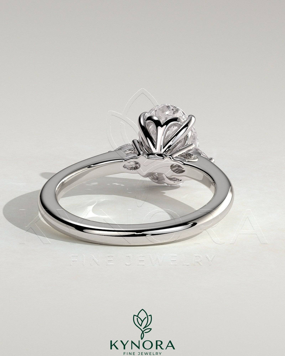 Kynora CJ 2ct oval claw trilogy engagement ring with pear side stones and tulip detail, showcasing elegant jewelry design.