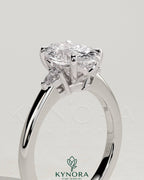 Kynora CJ 2ct oval claw trilogy engagement ring with pear side stones and tulip detail, showcasing intricate craftsmanship.