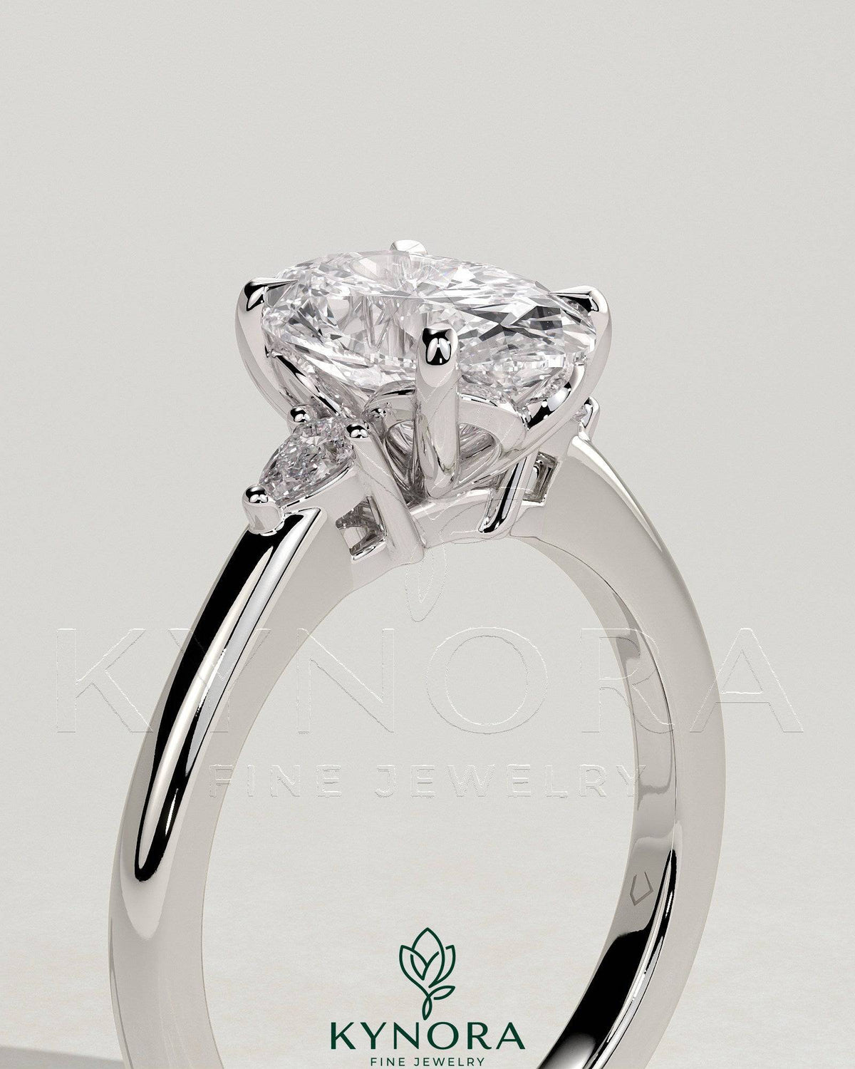 Kynora CJ 2ct oval claw trilogy engagement ring with pear side stones and tulip detail, showcasing intricate craftsmanship.