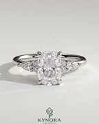 Kynora CJ 2ct elongated cushion claw solitaire engagement ring with pear accents and round shoulder stones, three-stone design.