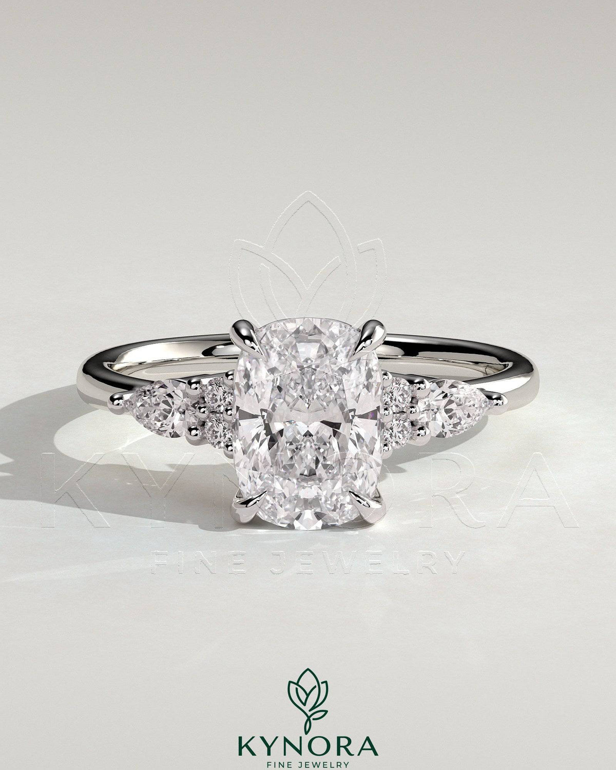 Kynora CJ 2ct elongated cushion claw solitaire engagement ring with pear accents and round shoulder stones, three-stone design.