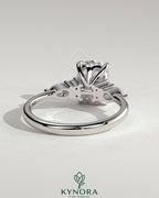 Kynora CJ 2ct elongated cushion solitaire engagement ring with pear accents and round shoulder stones, three stone design.