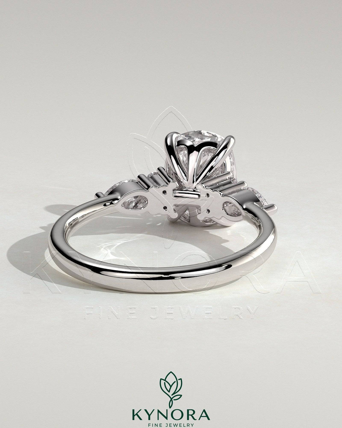 Kynora CJ 2ct elongated cushion solitaire engagement ring with pear accents and round shoulder stones, three stone design.