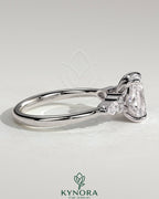 Kynora CJ 2ct elongated cushion claw solitaire engagement ring with pear accents and round shoulder stones, elegant three-stone design