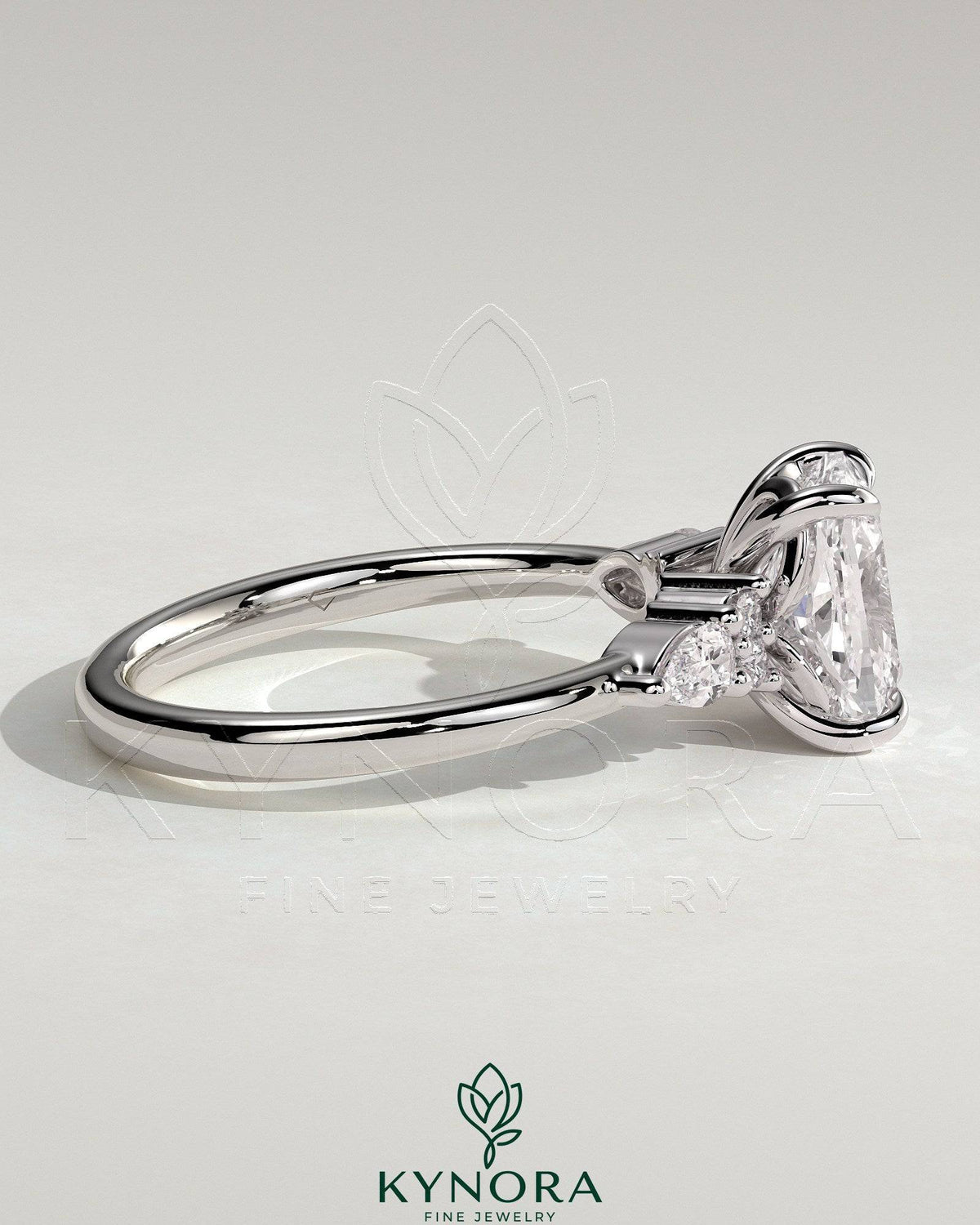 Kynora CJ 2ct elongated cushion claw solitaire engagement ring with pear accents and round shoulder stones, elegant three-stone design