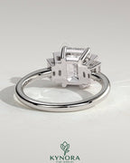 Kynora CJ 2ct emerald claw trilogy engagement ring with graduating baguette shoulder stones, three-stone design, fine jewelry.