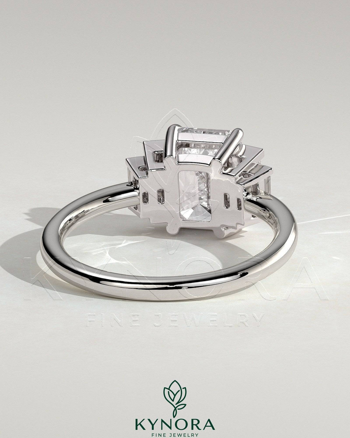 Kynora CJ 2ct emerald claw trilogy engagement ring with graduating baguette shoulder stones, three-stone design, fine jewelry.