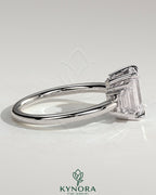 Kynora CJ 2ct emerald claw trilogy engagement ring with graduating baguette shoulder stones, elegant three-stone design.