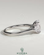 Two-carat elongated cushion cut trilogy engagement ring by Kynora CJ with round side stones and floral lily detail.