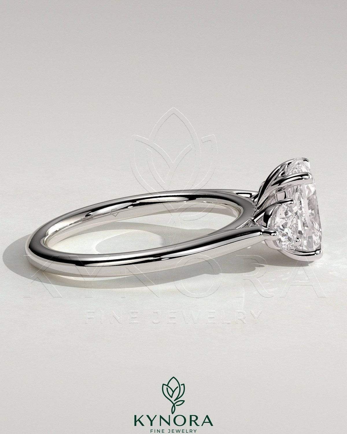 Two-carat elongated cushion cut trilogy engagement ring by Kynora CJ with round side stones and floral lily detail.
