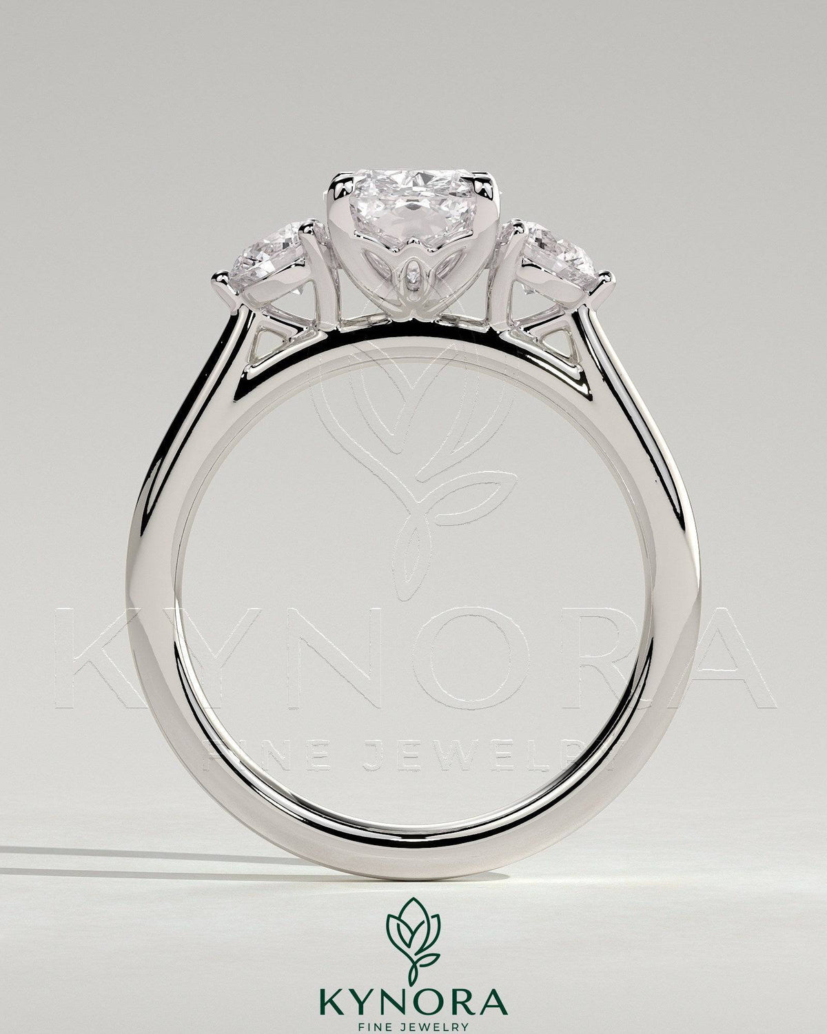 Kynora CJ 2ct elongated cushion claw trilogy engagement ring with round side stones and lily detailing in sterling silver.