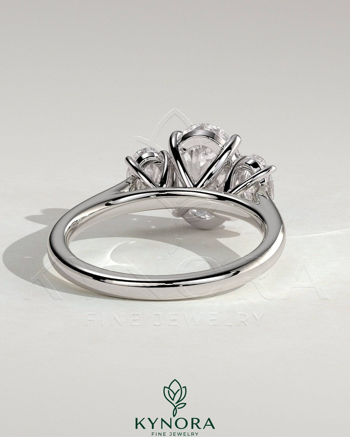 Kynora CJ 2ct oval claw trilogy engagement ring featuring oval side stones, elegant three-stone design with sparkling diamond accents.