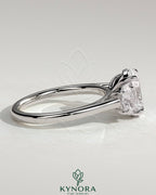 Kynora CJ 2ct oval claw trilogy engagement ring with oval side stones, showcasing a three stone design in polished metal.