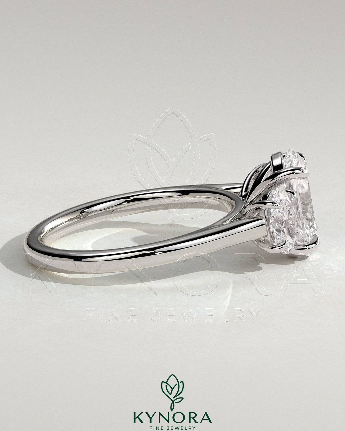 Kynora CJ 2ct oval claw trilogy engagement ring with oval side stones, showcasing a three stone design in polished metal.