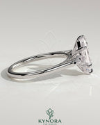 Kynora CJ three-stone engagement ring with 2-carat elongated hexagon claw trilogy design and kite-shaped side stones.
