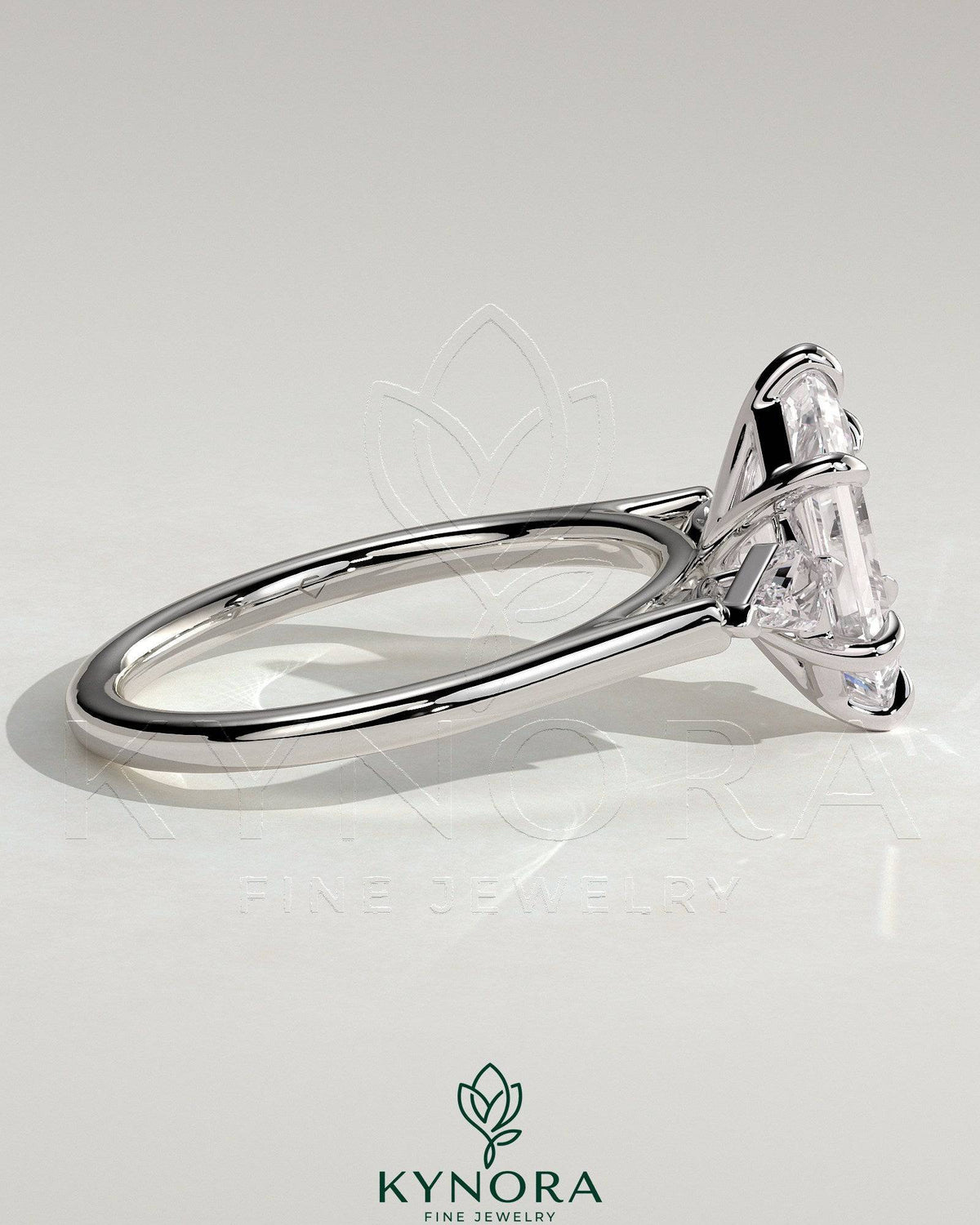 Kynora CJ three-stone engagement ring with 2-carat elongated hexagon claw trilogy design and kite-shaped side stones.