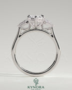 Kynora CJ 2ct elongated hexagon claw trilogy engagement ring with kite side stones, three-stone design, sparkling diamond accents.