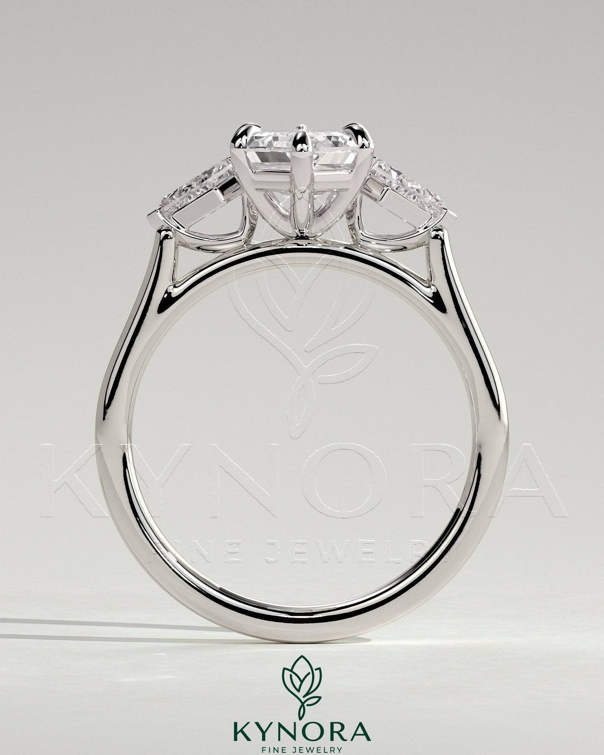 Kynora CJ 2ct elongated hexagon claw trilogy engagement ring with kite side stones, three-stone design, sparkling diamond accents.