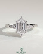 Kynora CJ 2ct elongated hexagon claw trilogy engagement ring with kite side stones, featuring three-stone design and intricate detailing.