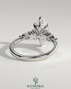 Kynora CJ 2ct marquise claw solitaire engagement ring with pear-shaped accents and round shoulder stones, elegant three-stone design.