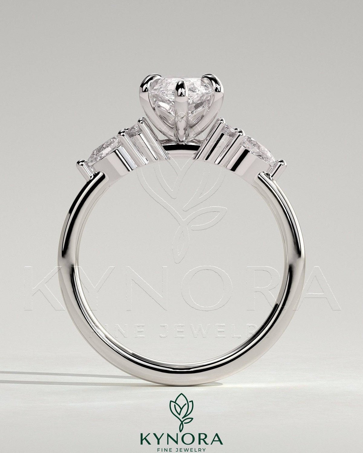 Kynora CJ three-stone engagement ring featuring a 2-carat marquise claw-set center with pear-shaped accents and round shoulder stones.