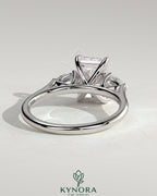Kynora CJ 2ct radiant claw trilogy engagement ring with pear side stones and cathedral setting, showcasing sparkling diamond design.