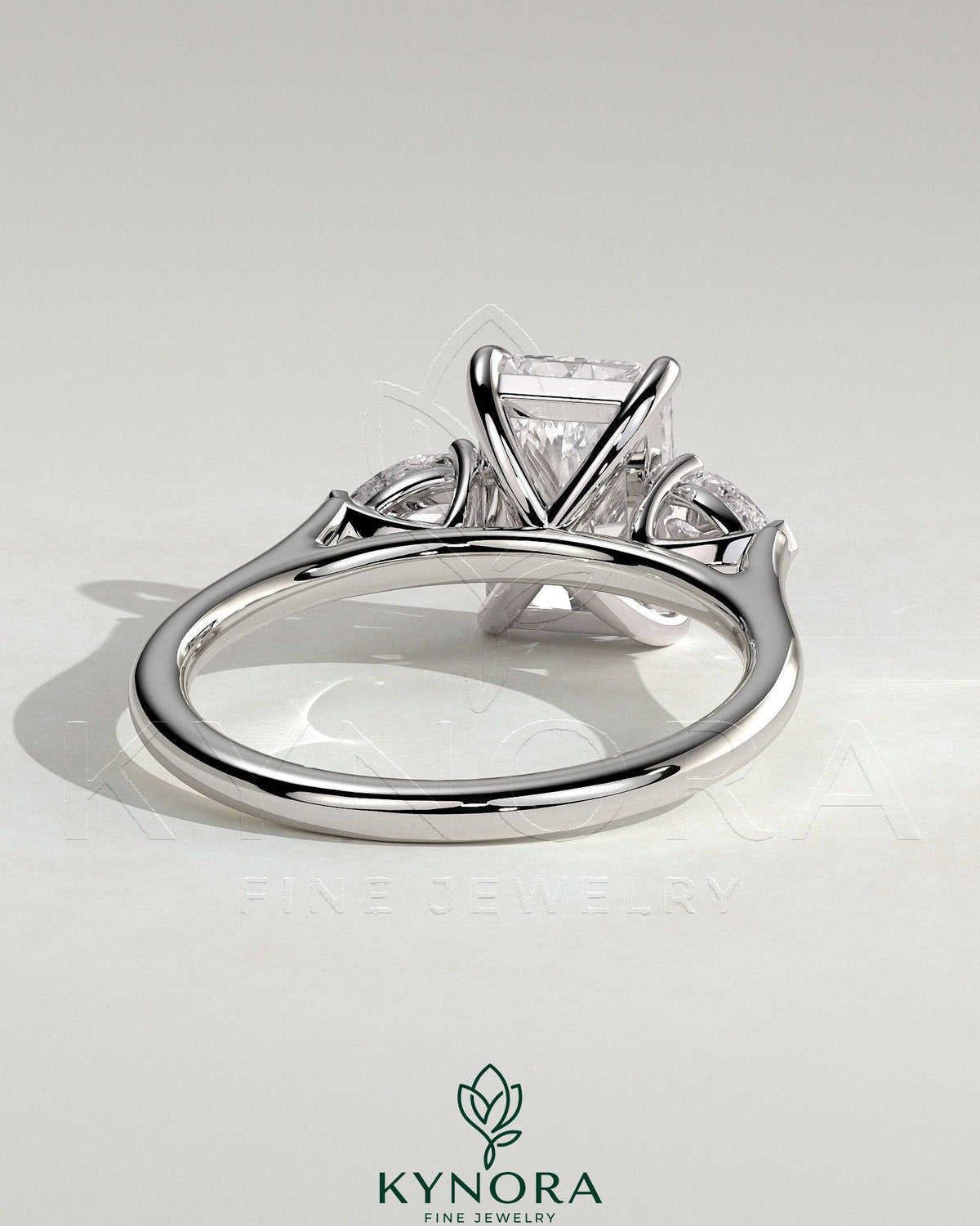 Kynora CJ 2ct radiant claw trilogy engagement ring with pear side stones and cathedral setting, showcasing sparkling diamond design.