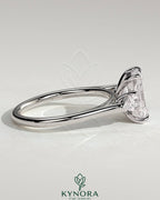 Kynora CJ 2ct radiant claw trilogy engagement ring with pear side stones and cathedral setting, showcasing sparkling diamond design.