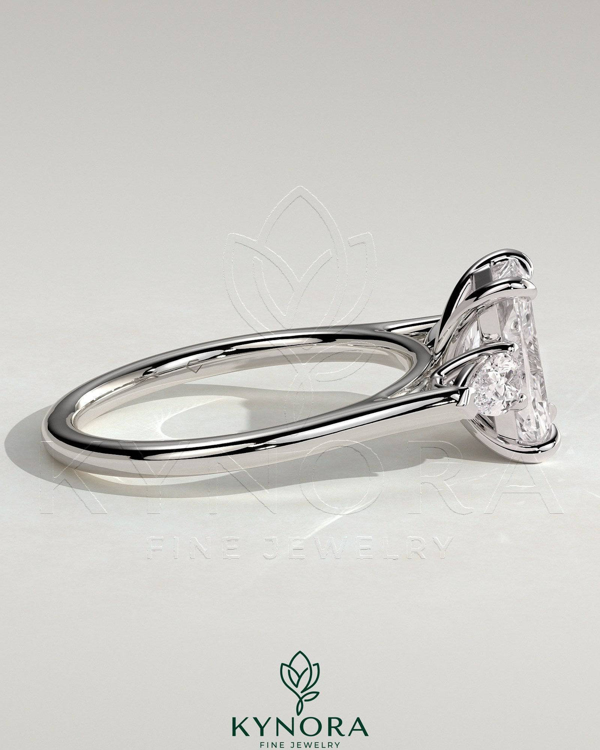 Kynora CJ 2ct radiant claw trilogy engagement ring with pear side stones and cathedral setting, showcasing sparkling diamond design.