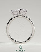 Kynora CJ 1.5ct pear-shaped and 1.8ct emerald-cut Toi et Moi engagement ring with claw setting, showcasing elegant gemstone design.