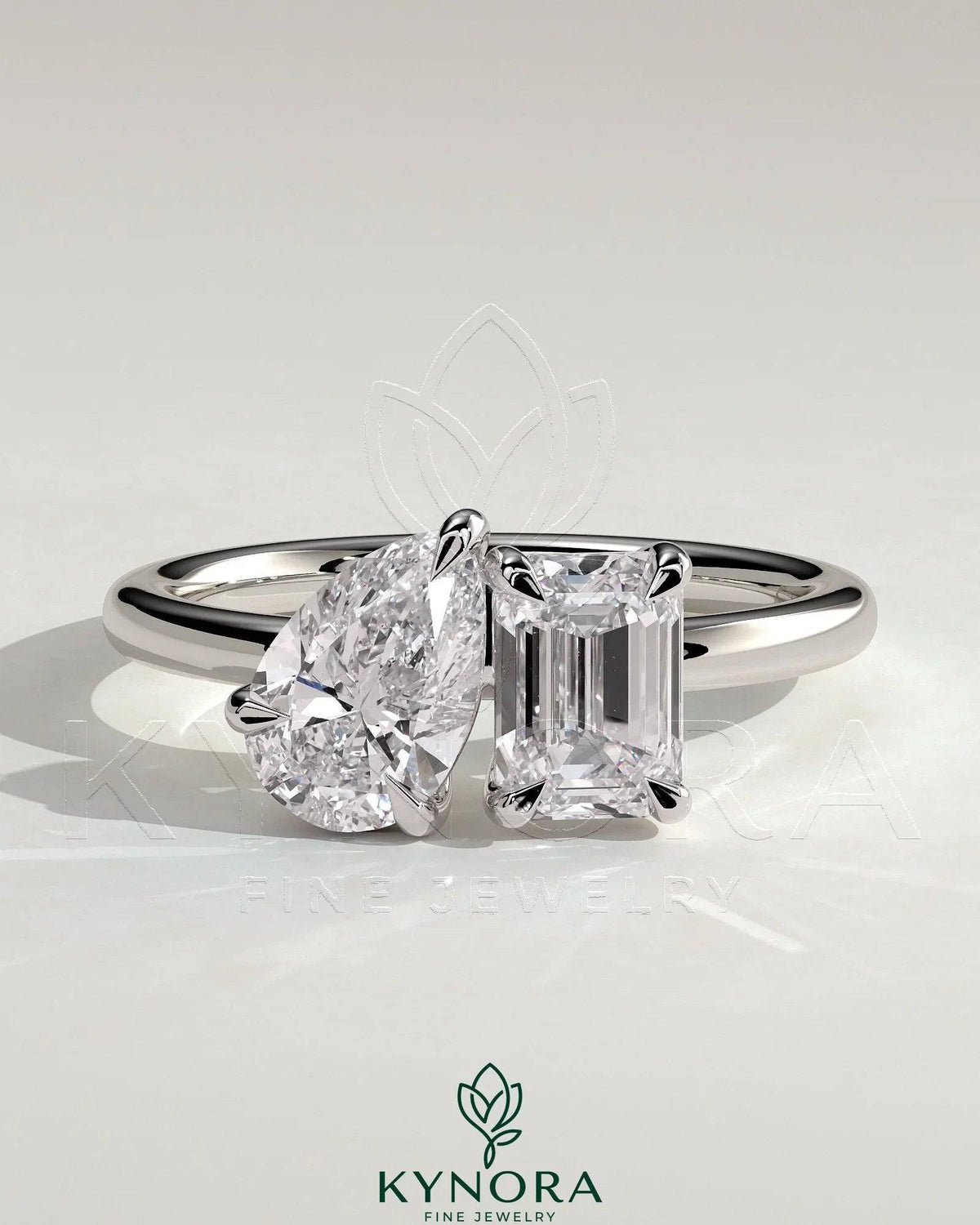 Kynora CJ Toi et Moi engagement ring featuring a 1.5ct pear-shaped and 1.8ct emerald-cut diamonds with claw settings. Imagen principal del producto