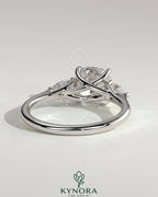 Kynora CJ 2ct cushion-shaped trilogy engagement ring with pear side stones and open trellis gallery design.