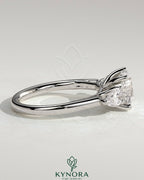 Kynora CJ 2ct round claw trilogy engagement ring with pear side stones and open trellis gallery design.