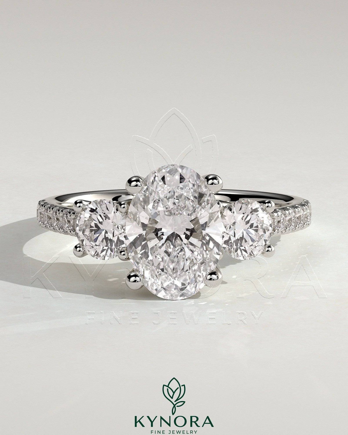 Kynora CJ 2ct oval claw trilogy engagement ring with round side stones, pave band, and trellis gallery design. Imagen principal del producto