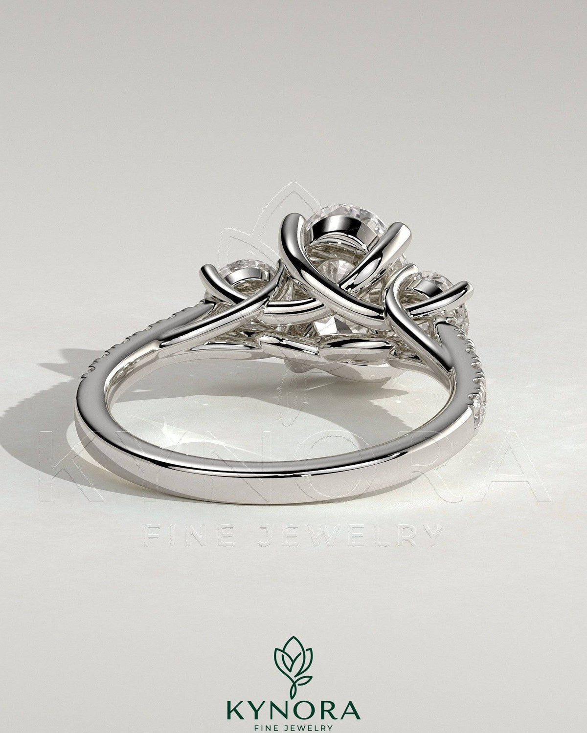 Kynora CJ 2ct oval claw trilogy engagement ring with round side stones, pave band and trellis gallery design.